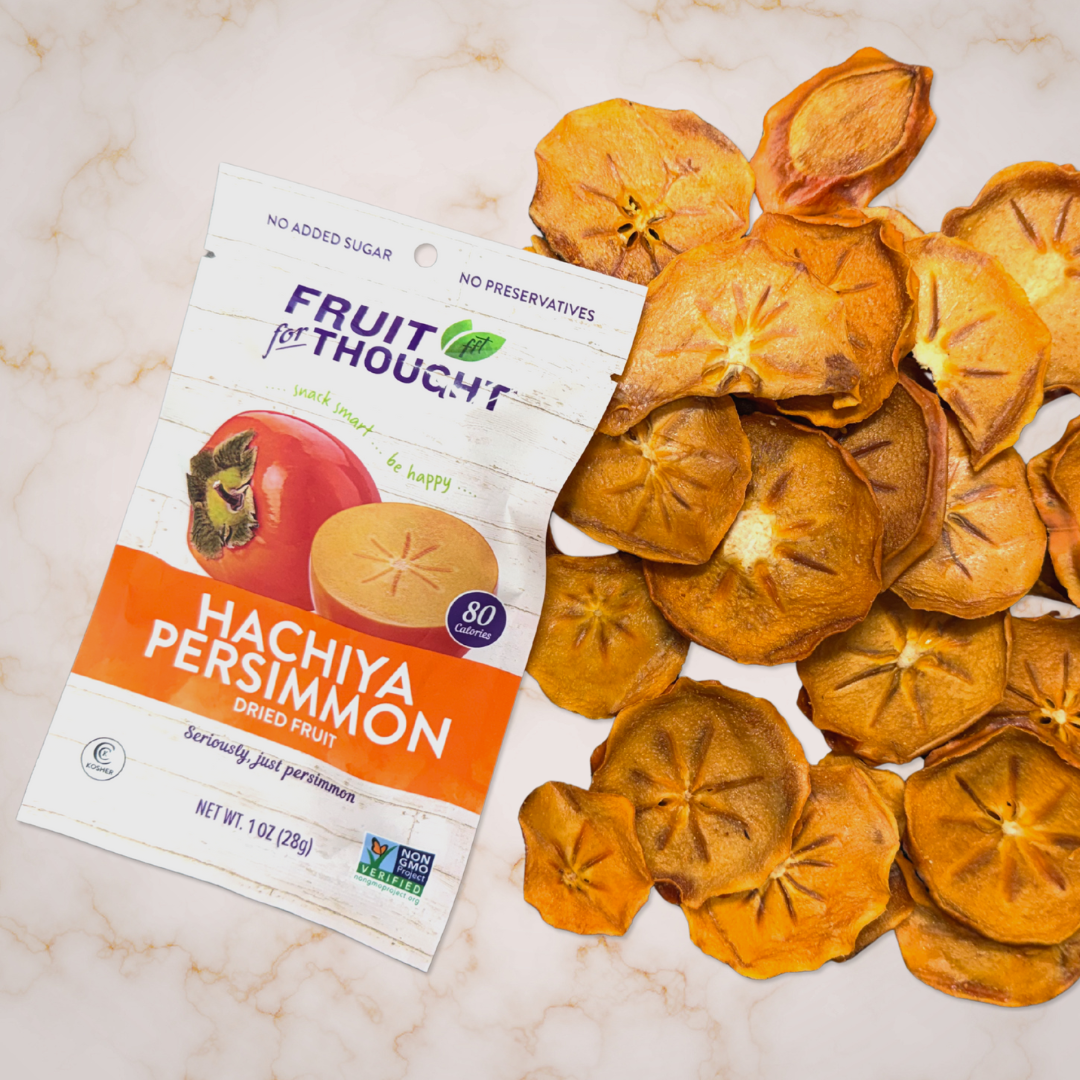 Dried persimmons on top of a pink marble countertop.